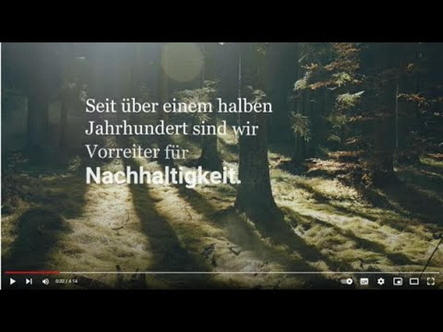 Ein sonnenbeschienener Wald mit Bäumen, die lange Schatten werfen. Der deutsche Text über dem Bild lautet: Seit über einem halben Jahrhundert sind wir Vorreiter für Nachhaltigkeit.