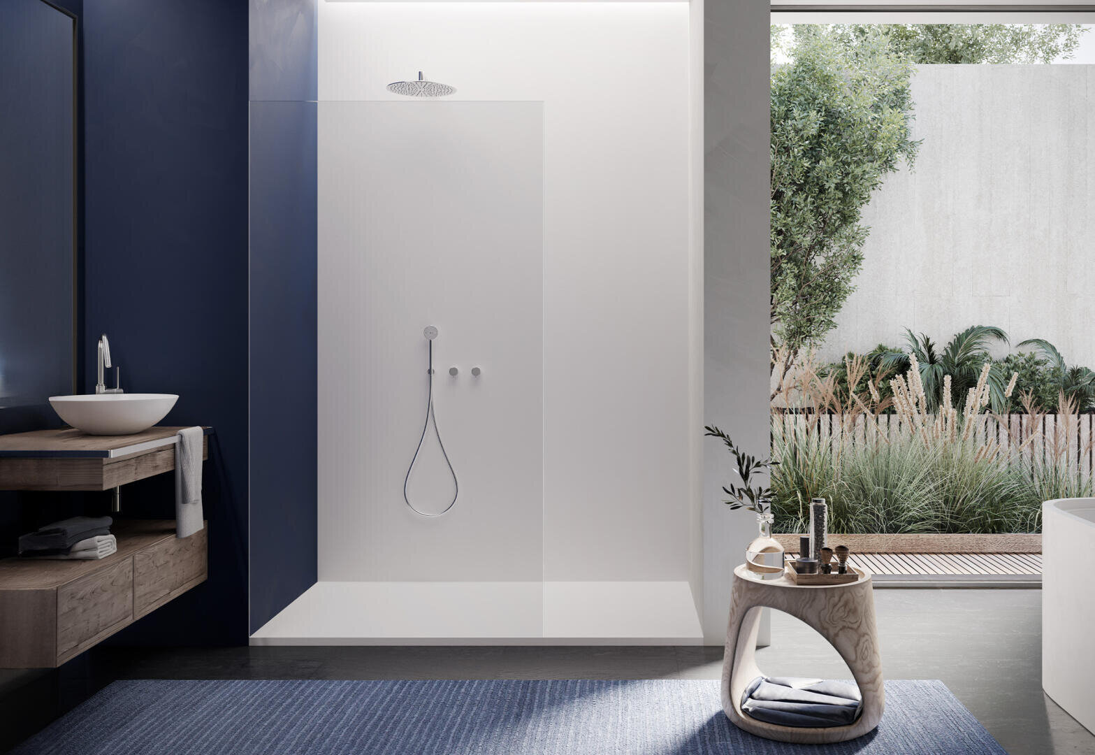 Ein modernes, minimalistisches Badezimmer mit einer begehbaren Dusche, einer Glaswand und einer Regendusche. Es gibt einen runden Hocker, einen blauen Teppich, einen hölzernen Waschtisch mit Gefäßwaschbecken und ein großes Fenster mit Blick auf einen Garten.