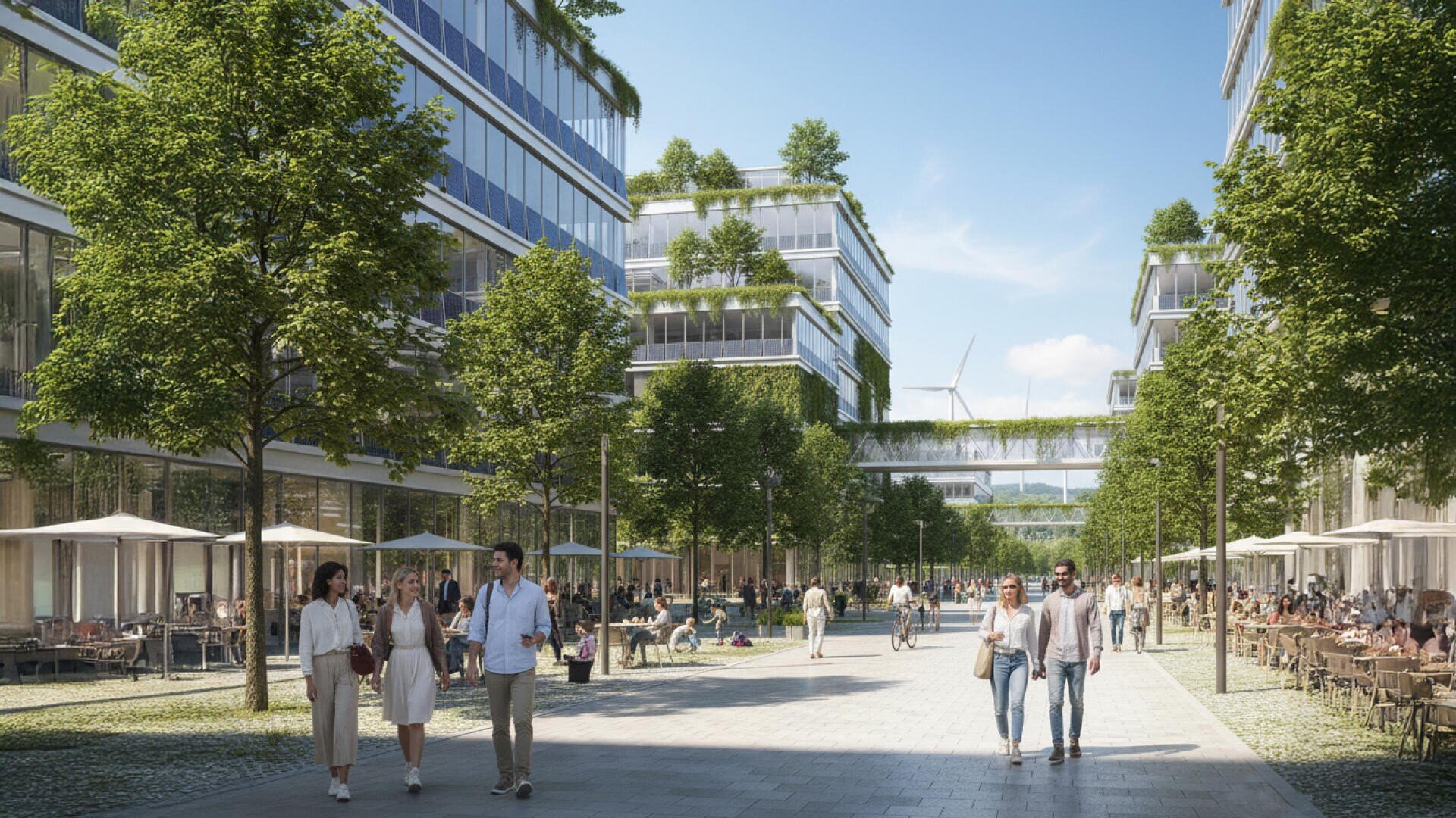 Eine breite, von Bäumen gesäumte Fußgängerpromenade verläuft zwischen modernen gläsernen Bürogebäuden. Die Menschen flanieren, sitzen in Straßencafés und entspannen sich auf Bänken unter einem sonnigen Himmel. Einige Gebäude haben Pflanzen auf ihren Terrassen.