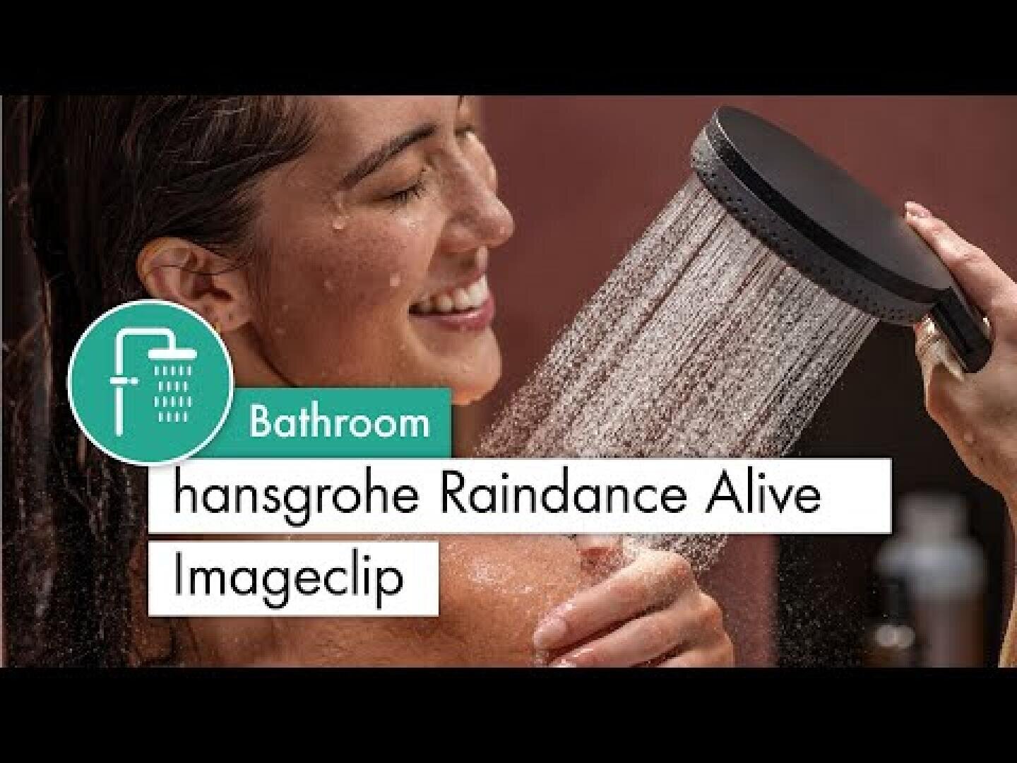 Eine lächelnde Frau genießt eine Dusche und hält einen schwarzen Handbrausekopf, der Wasser versprüht. Der Text lautet: Badezimmer hansgrohe Raindance Alive Imageclip.