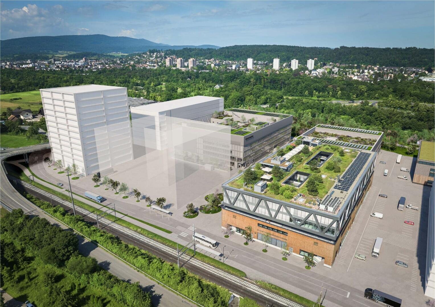 Ein moderner Industriekomplex mit Solarmodulen und grünen Dächern, umgeben von Bäumen und nahegelegenen Bahngleisen, mit Stadtgebäuden und bewaldeten Hügeln im Hintergrund. Einige Gebäude sind als transparente Architekturdarstellungen dargestellt.