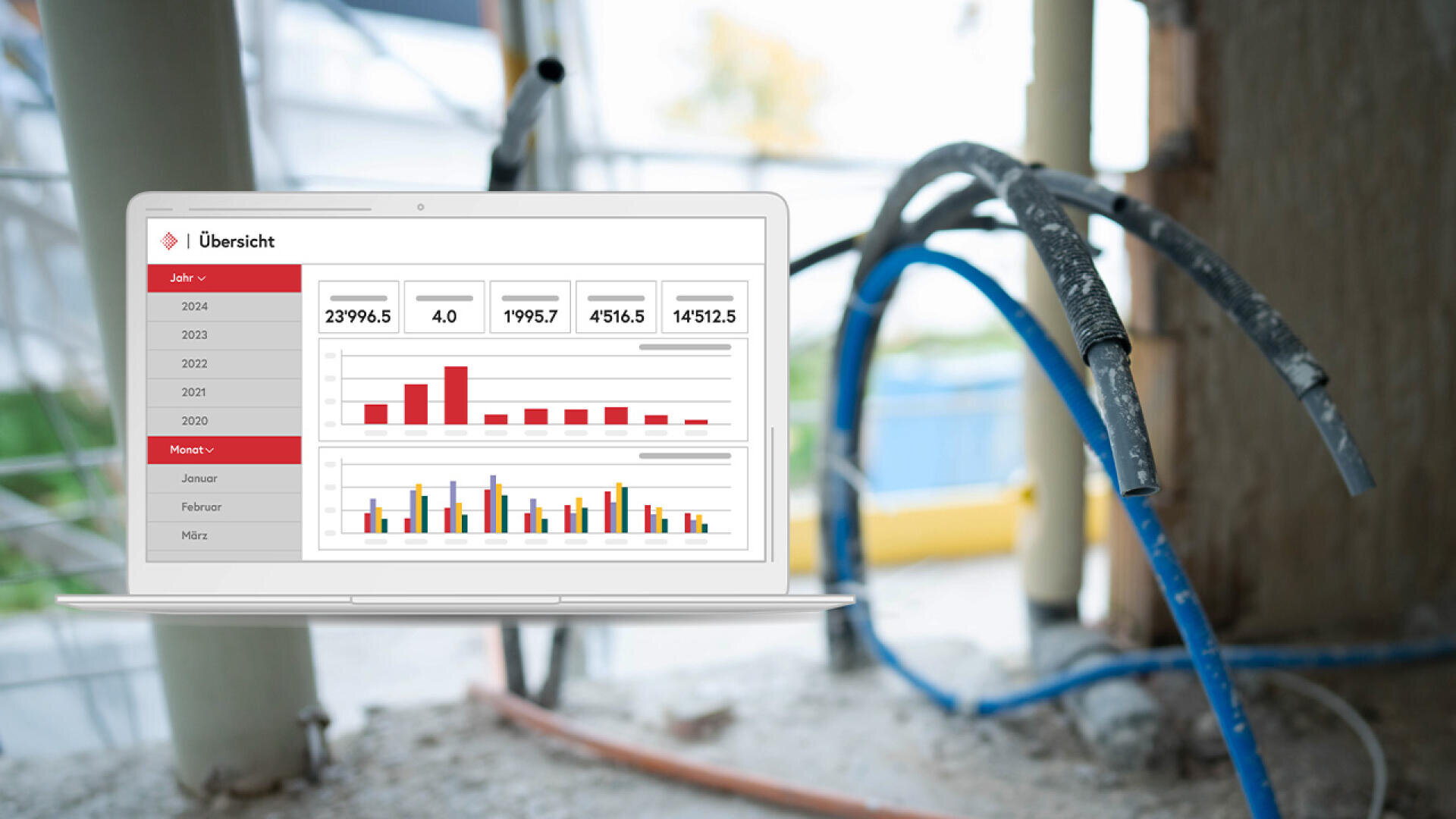 Ein Laptop zeigt ein Dashboard von Abacus ERP mit Balkendiagrammen und Datentabelle, das auf einer Baustelle mit freiliegenden Kabeln und einer unfertigen Wand im Hintergrund steht.