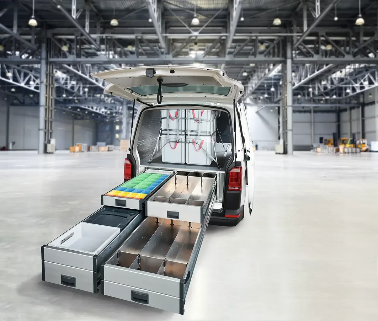 Ein weißer Lieferwagen parkte in einem großen, leeren Lagerhaus, dessen Hecktür geöffnet war und geordnete Schubladen mit Werkzeugen, Behältern und Vorräten enthielt.
