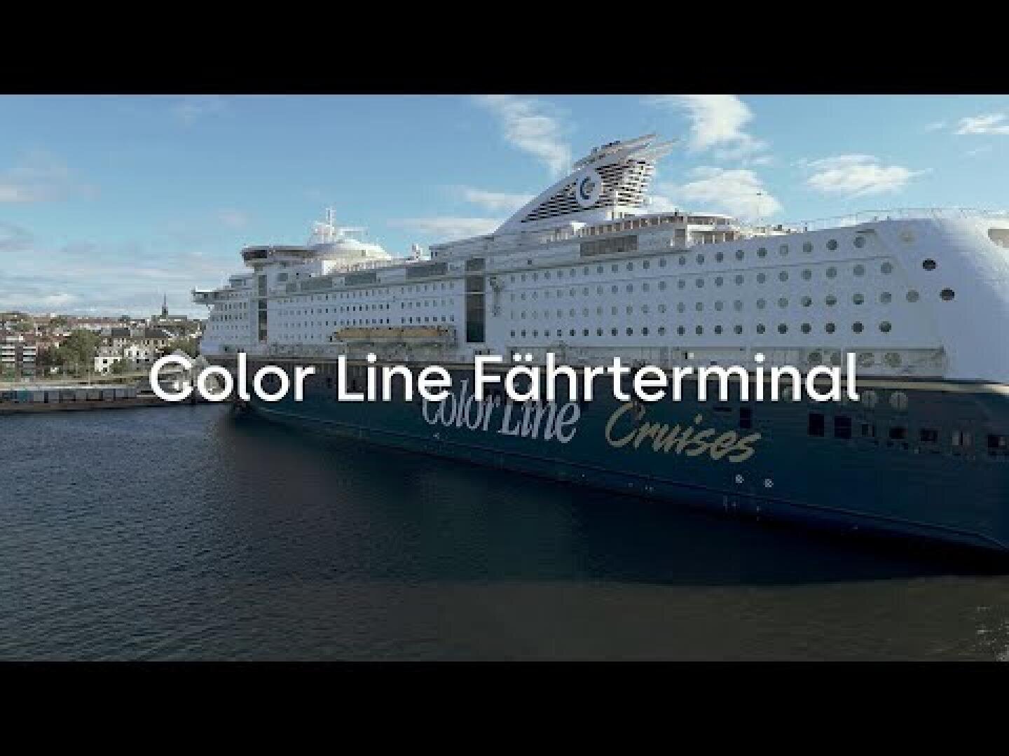 Ein großes Schiff von Color Line Cruises ist an einem Terminal in der Nähe des Wassers angedockt, wobei der Text Color Line Fährterminal über das Bild gelegt ist. Der Himmel ist teilweise bewölkt und im Hintergrund sind Gebäude zu sehen.