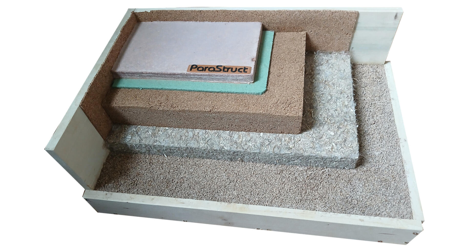 Ein hölzerner Schaukasten mit vier gestapelten Schichten verschiedener Baumaterialien, darunter Dämmstoffe, Faserplatten und eine beschriftete Tafel mit der Aufschrift ParaStruct.