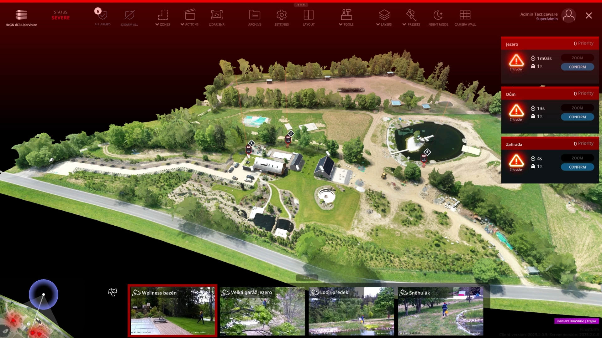 Une carte aérienne en 3D d'un parc avec des bâtiments, des chemins, des espaces verts et des étangs s'affiche sur une interface informatique, avec des messages d'alerte et des transmissions de caméras en direct en bas et à droite de l'écran.