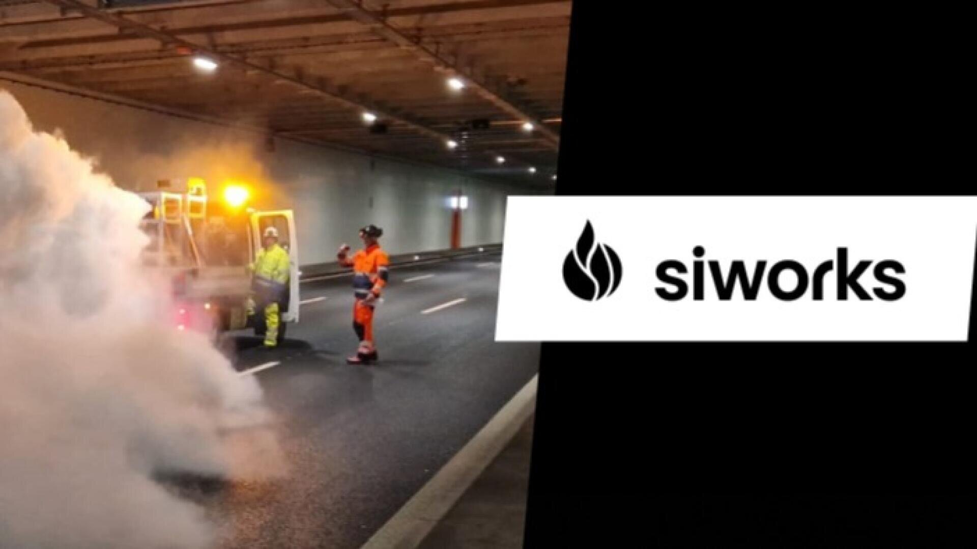 Deux travailleurs en tenue de sécurité se tiennent près d'un véhicule dégageant de la fumée dans un tunnel. La partie droite de l'image montre le logo SiWorks avec une icône de flamme noire et le texte "siworks" sur un fond blanc.
