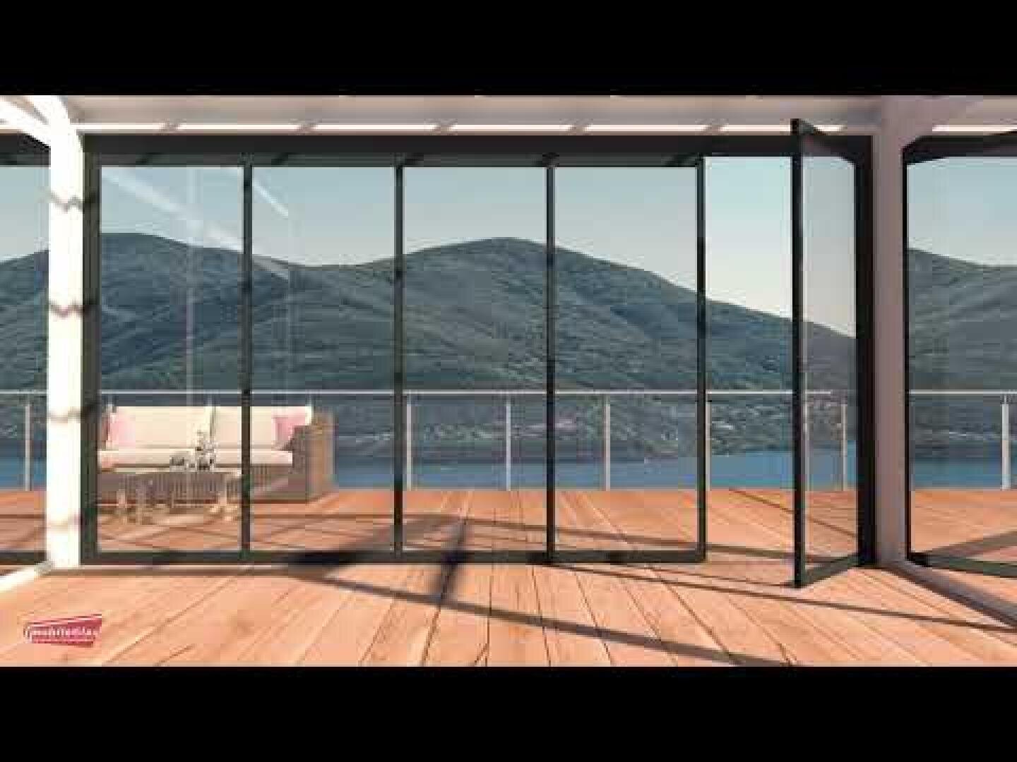 Une porte pliante en verre s'ouvre sur une terrasse en bois avec vue sur les montagnes et un lac. Un canapé d'extérieur clair se trouve sur la terrasse, partiellement ombragée par une pergola.