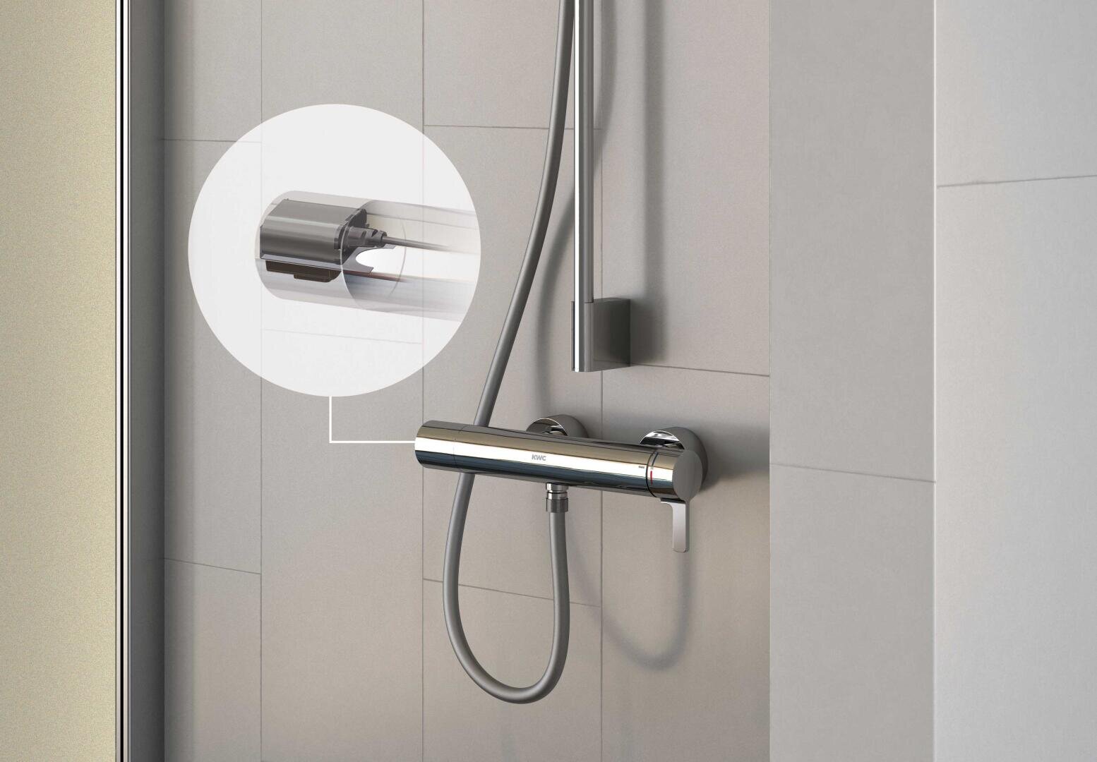 Un système de douche moderne avec une douchette à main chromée fixée à un support mural. Un cercle en médaillon fait un zoom sur le support métallique et élégant de la pomme de douche, fixé sur des murs carrelés gris clair.