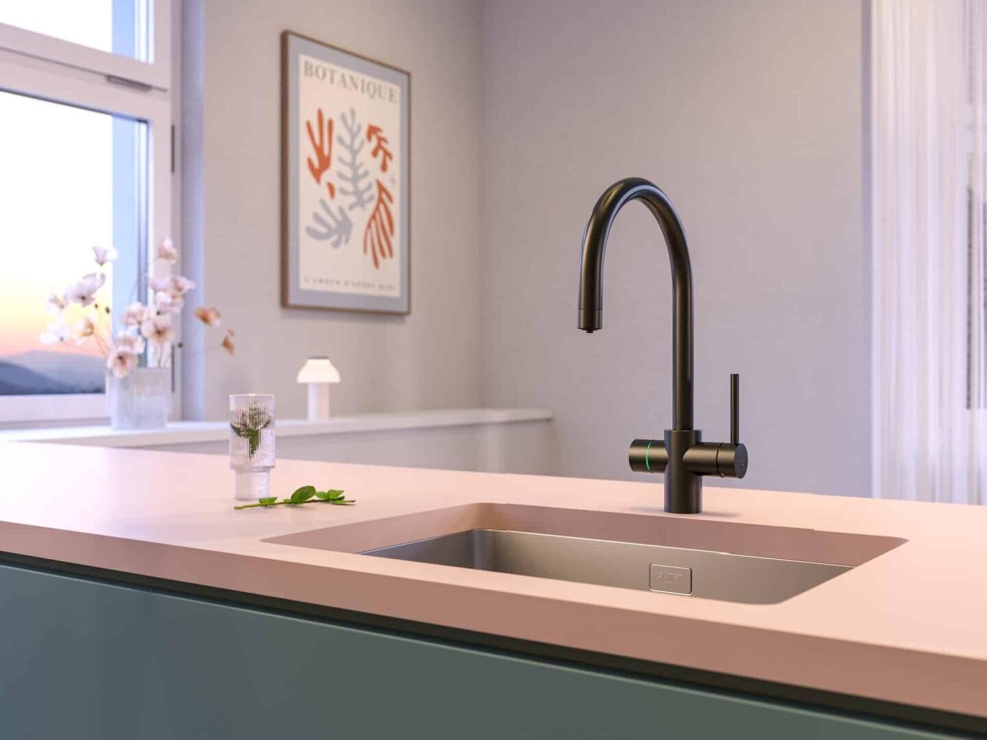 Moderne Küche mit einem mattschwarzen Wasserhahn, einer rosafarbenen Arbeitsplatte und einem Waschbecken aus Edelstahl. Im Hintergrund sind eine sanfte Beleuchtung, ein gerahmter botanischer Druck und eine Vase mit Blumen zu sehen.