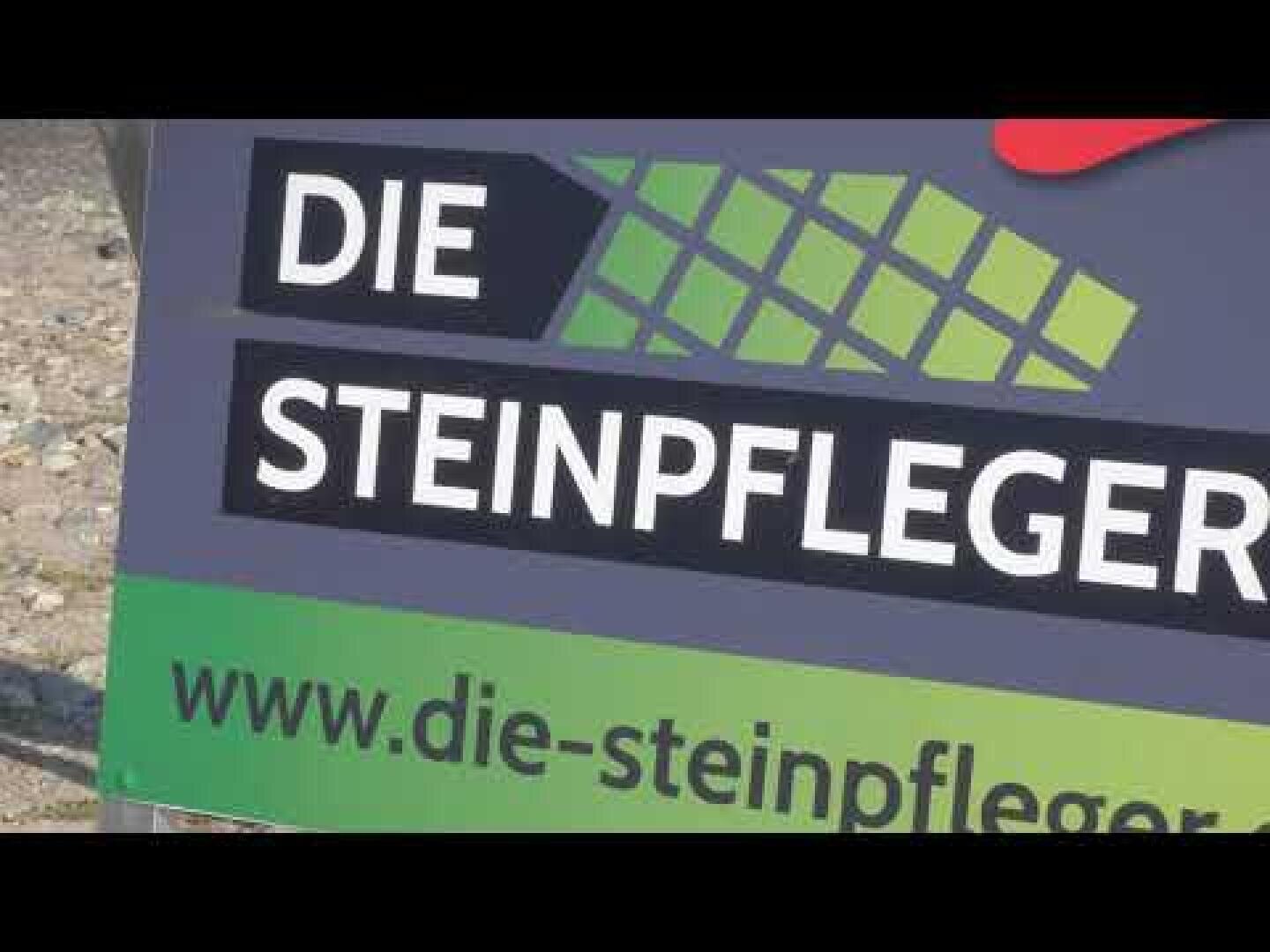 Ein Schild mit dem Text DIE STEINPFLEGER und einer grünen Kachelgrafik über einer Website-URL www.die-steinpfleger.de. Der Hintergrund ist grau und grün.