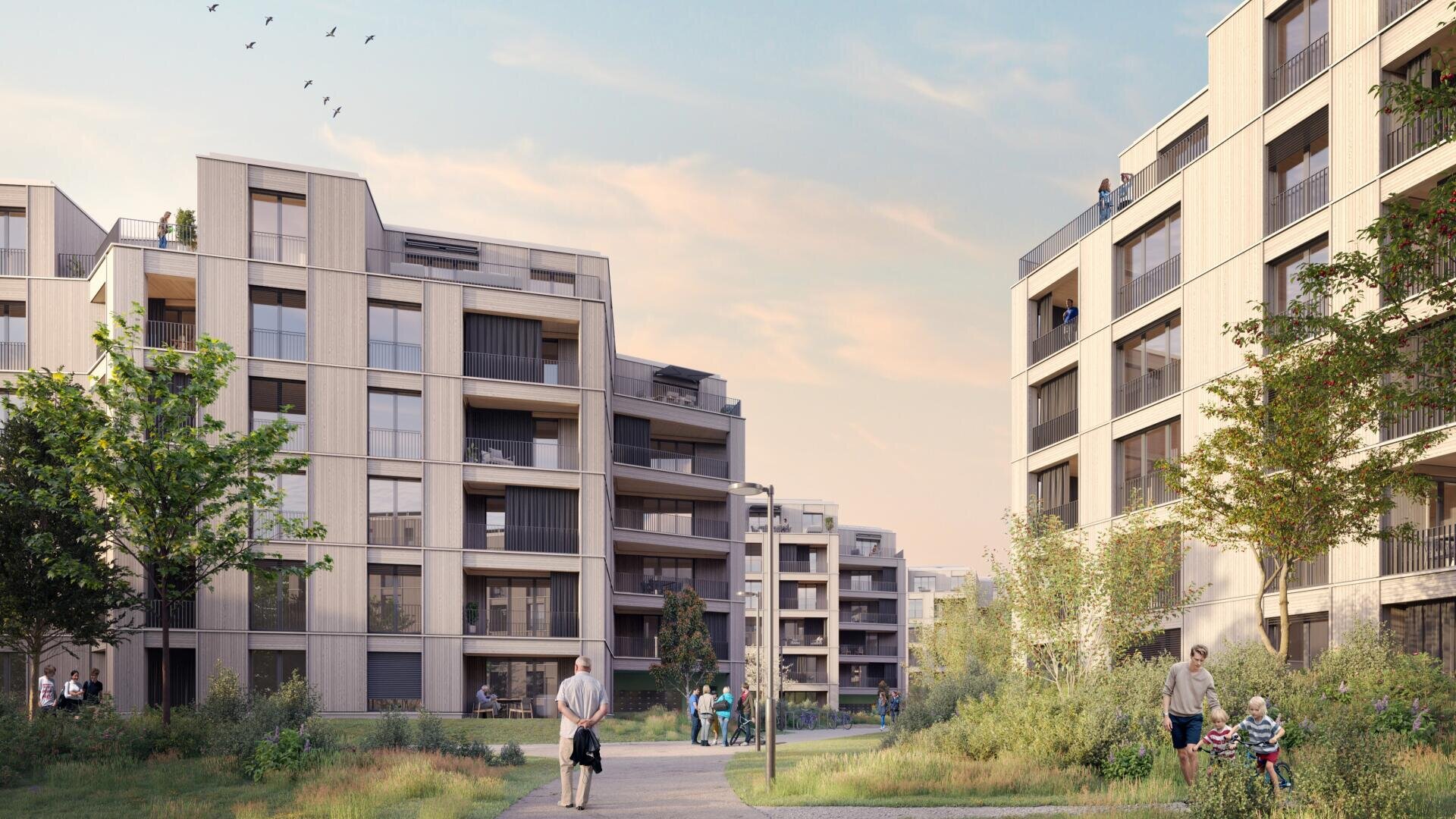 Moderne Wohngebäude umgeben einen begrünten Spazierweg mit flanierenden Menschen, spielenden Kindern und Grünflächen. Der Himmel ist teilweise bewölkt und Vögel fliegen darüber, was eine ruhige, einladende Wohnatmosphäre schafft.