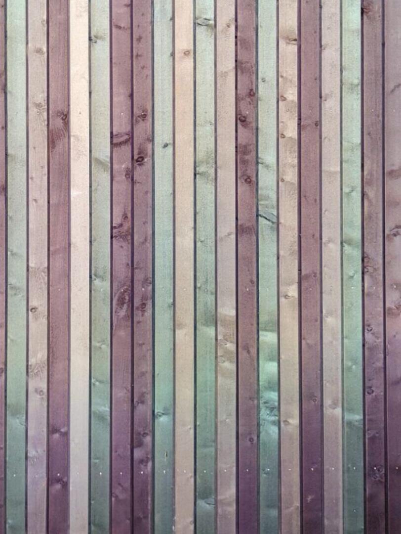 Vertikale Holzbretter mit einem Farbverlauf von Braun und Beige bis Grün und Violett, die die natürliche Holzmaserung und Äste zeigen.
