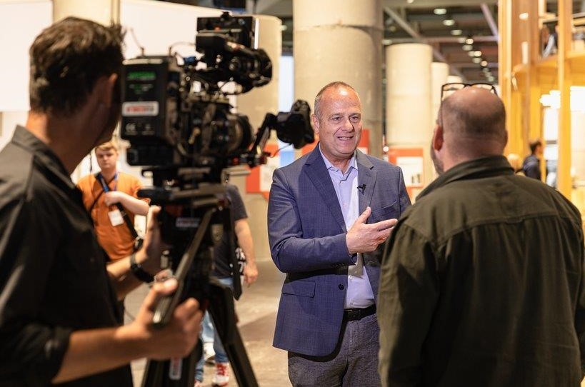 Journalist macht ein Fotos eines Sprechers auf der Bühne an der Holz Messe.