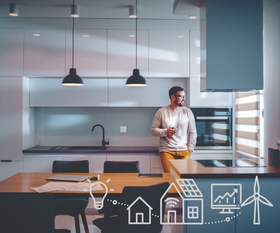 Ein Mann steht in einer modernen Küche, hält einen Becher und schaut aus dem Fenster. Weiße Liniensymbole einer Glühbirne, eines Hauses, eines Solarpanels, von Graphen und einer Windturbine werden auf dem Bild im Vordergrund überlagert.