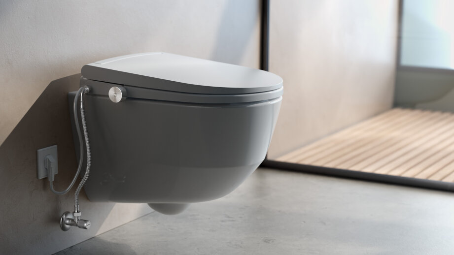 Ein modernes Wand-WC mit geschlossenem Deckel, mit Bidet-Brauseaufsatz und minimalistischem Baddekor in neutralen Tönen.