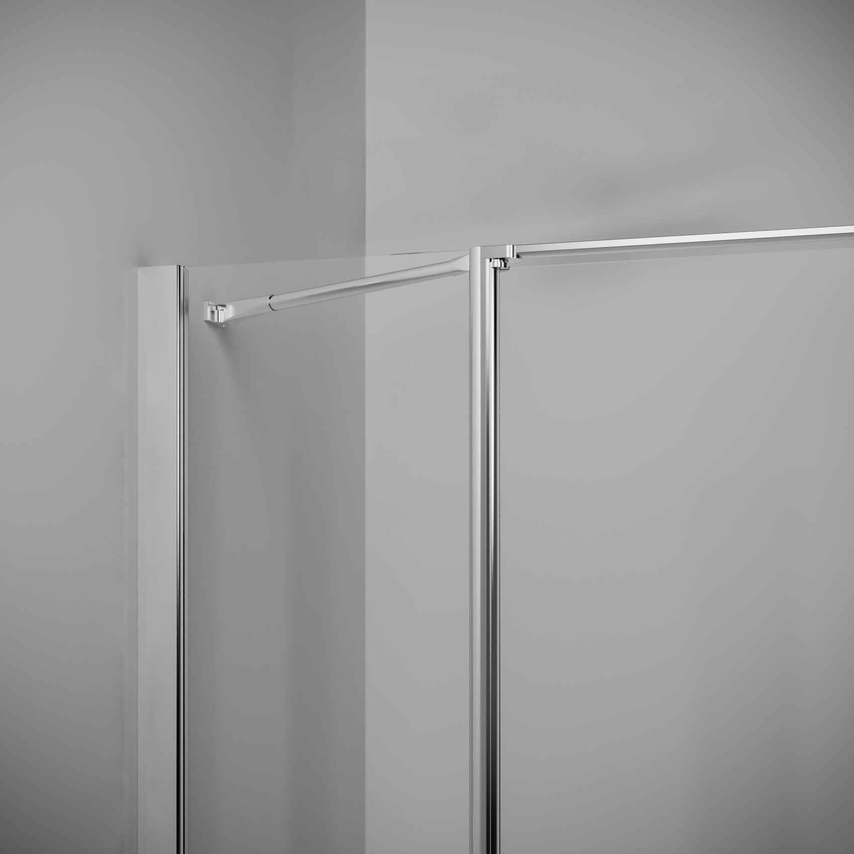 Vue rapprochée d'une cabine de douche moderne en verre avec des cadres métalliques et un rail de porte coulissante monté, sur un mur gris clair.